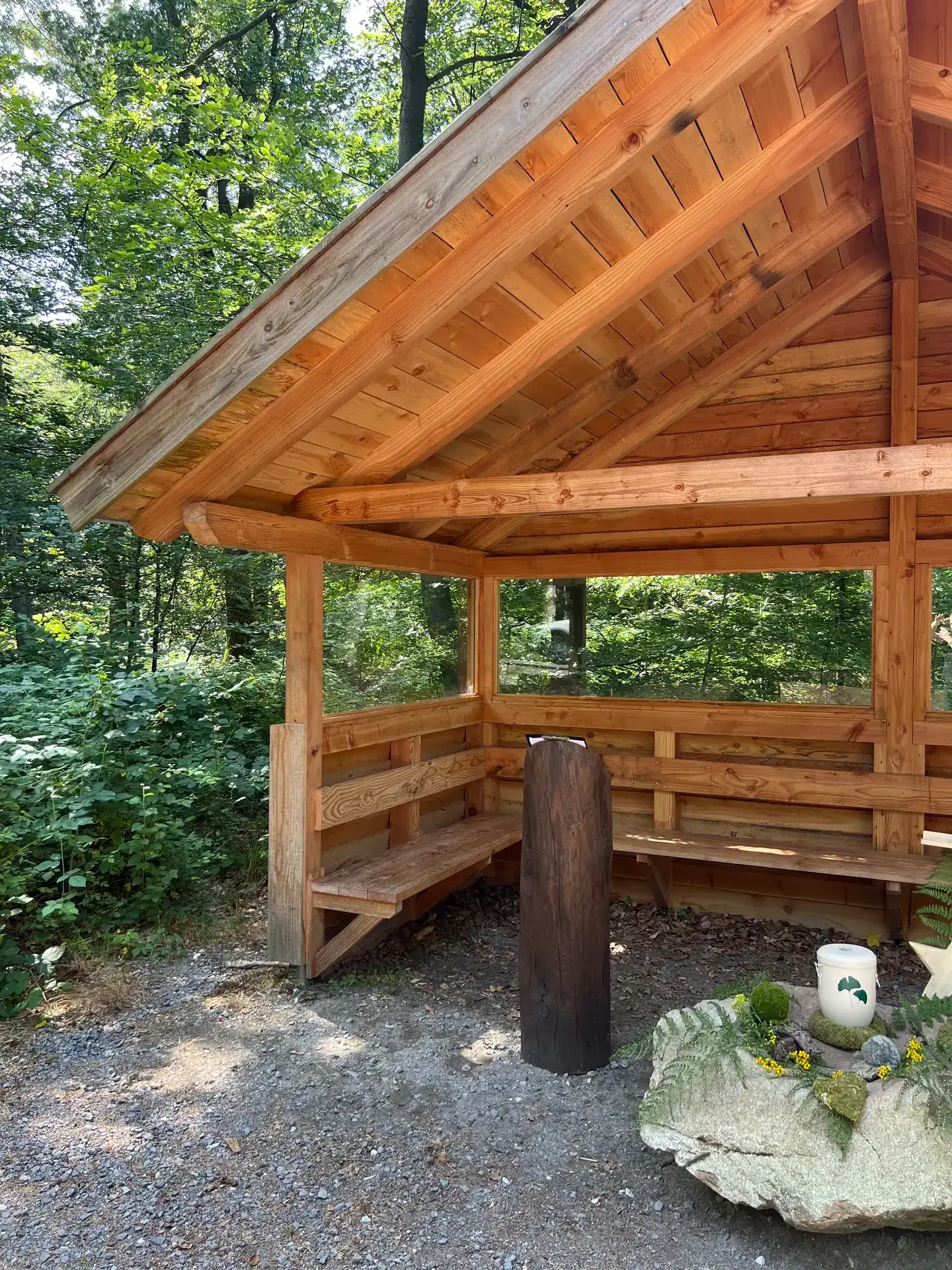 Hölzerner Andachtsplatz im FriedWald im sommerlichen Grün
