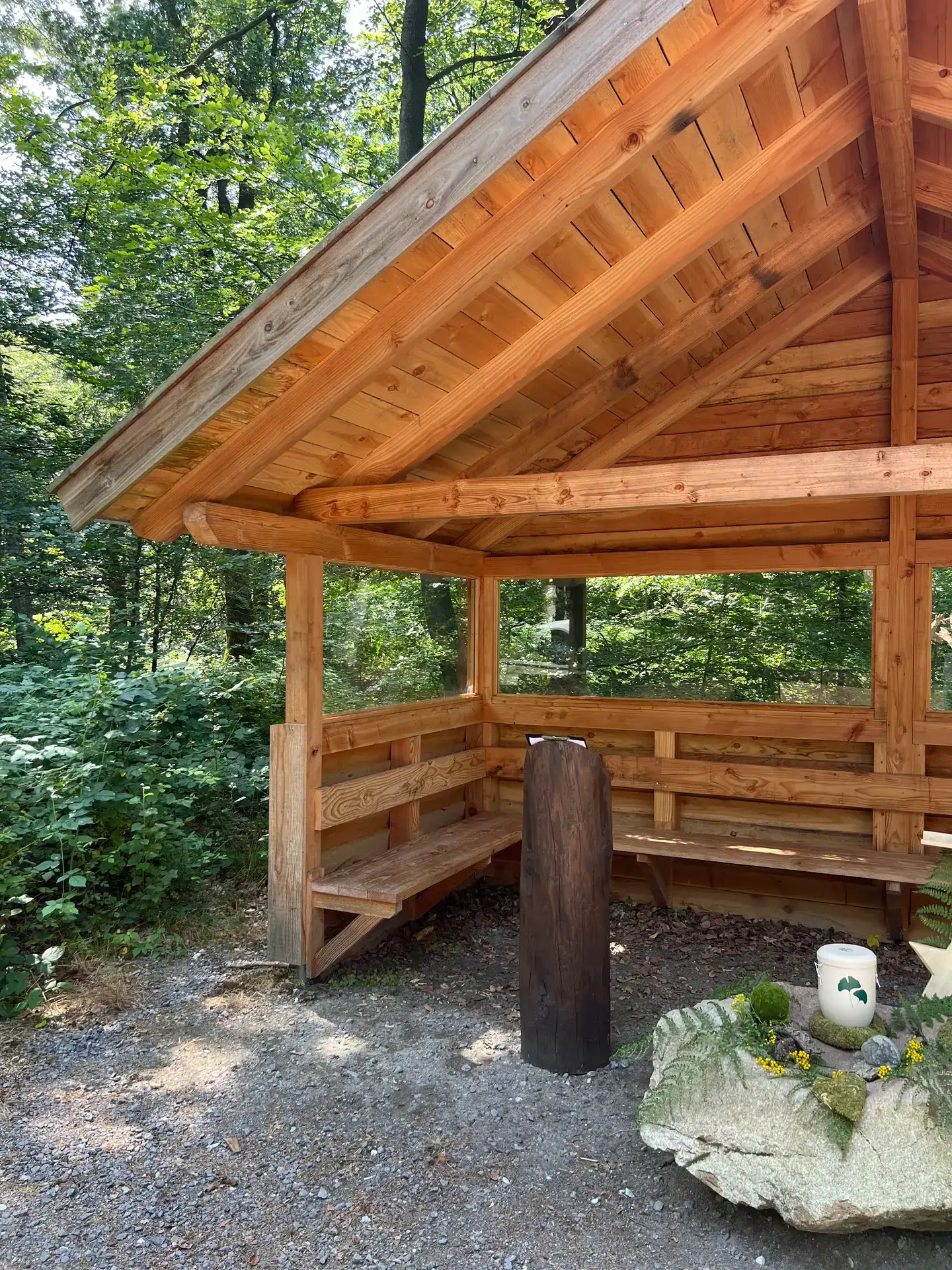 Hölzerner Andachtsplatz im FriedWald im sommerlichen Grün