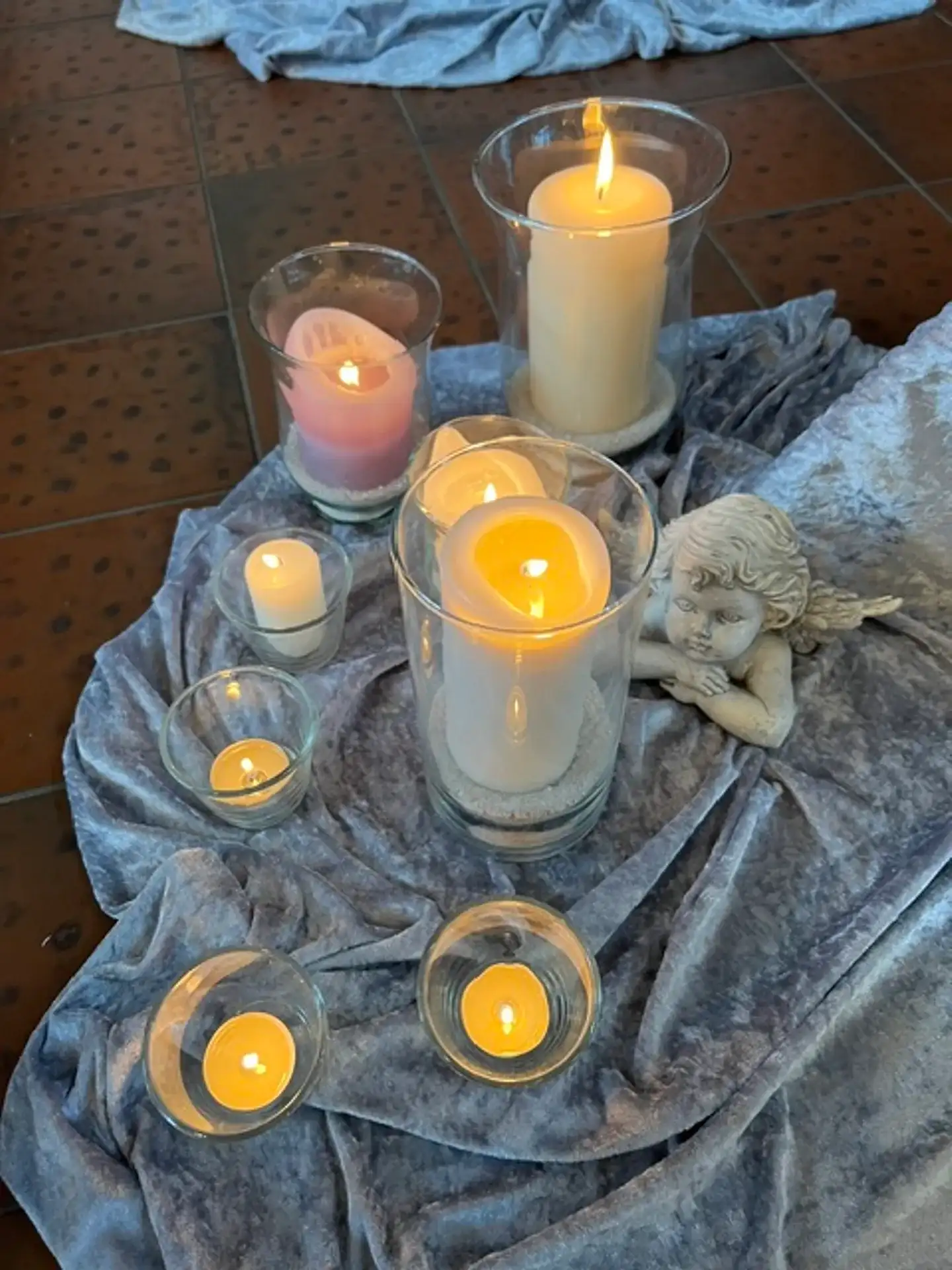 Kerzenarrangement mit einer Engelsfigur als Teil der Trauerdekoration