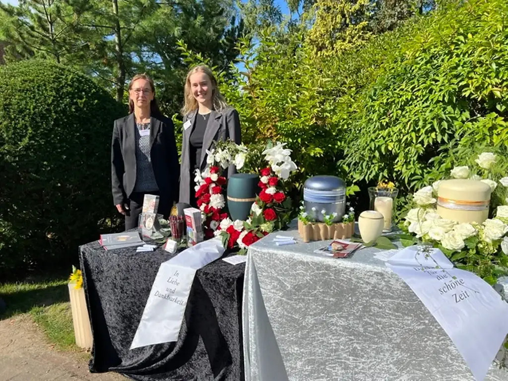 Tania und Nadia Genthe an einem Ausstellungstisch mit Urnen und Blumenschmuck